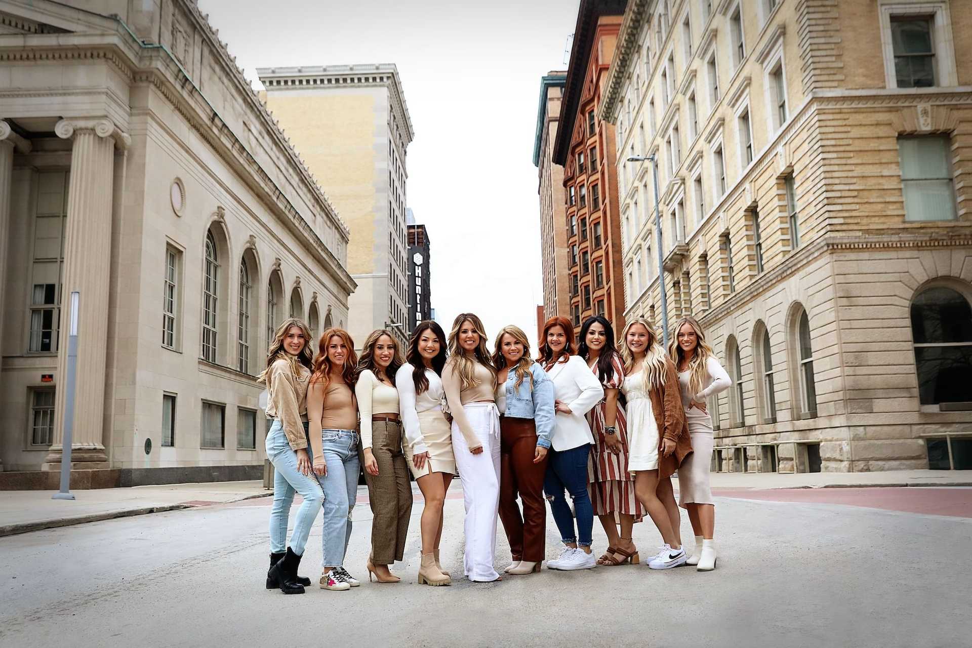 Group of women posing together on an urban street.